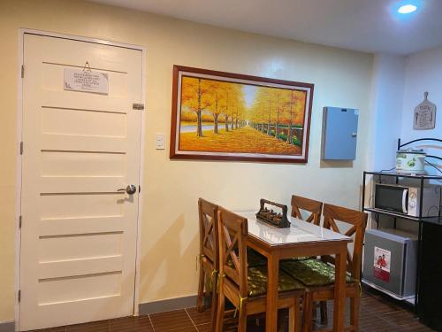 a dining room with a table and a painting on the wall at A nature’s den in Tagaytay in Tagaytay