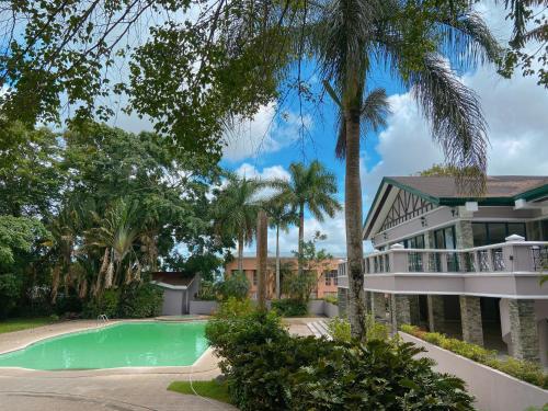 a house with a swimming pool and palm trees at A nature’s den in Tagaytay in Tagaytay