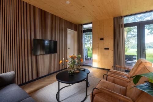 a living room with a couch and a table at Zicht op Twente - Spa lodges in Markelo