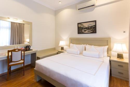 a bedroom with a large white bed and a desk at Serene Villa 38 in Kandy