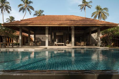 a resort with a swimming pool and a pavilion at Kirana - A Santani Villa in Bentota