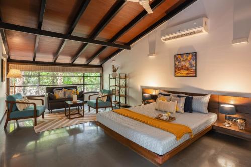 a bedroom with a bed and a living room at LohonoStays Villa Orchard House in Revas