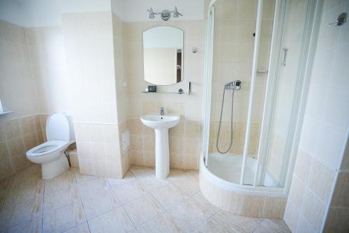 W łazience znajduje się toaleta, umywalka i prysznic. w obiekcie Hotel Wilanów w Warszawie