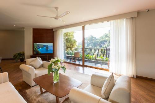 a living room with white furniture and a large window at Serene Villa 38 in Kandy