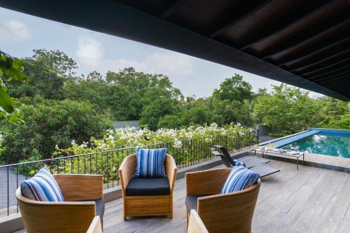 una terrazza con sedie e una piscina di LohonoStays Villa Orchard House 