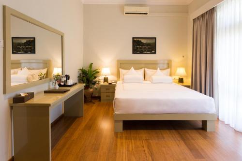 a bedroom with a bed and a desk and a mirror at Serene Villa 38 in Kandy