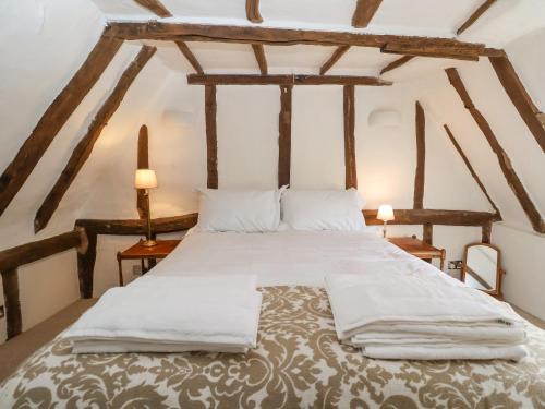 a large bed in a room with wooden beams at The Nook in Cavendish