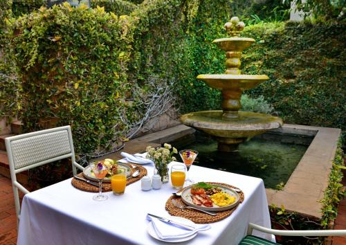 a table with plates of food and a fountain at The Vineyard on Ballito in Ballito