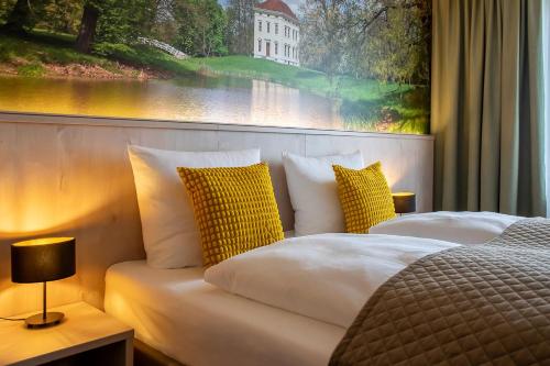 a bedroom with two beds and a large window at Hotel Restaurant Elbebrücke in Oranienbaum-Wörlitz