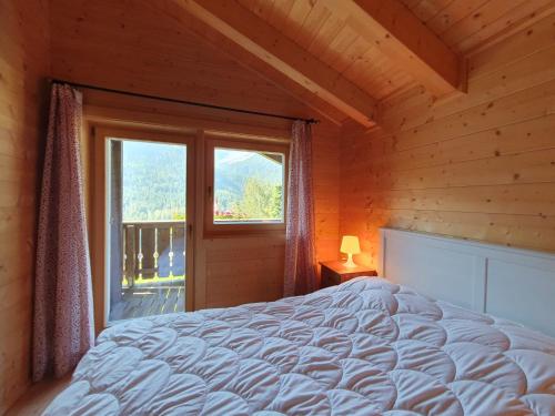 a bedroom with a large bed and a window at Chalet Dalpe by Quokka 360 - chalet among pastures and forests in Dalpe