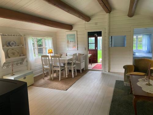 uma sala de jantar com mesa e cadeiras em Charming Cottage em Roskilde