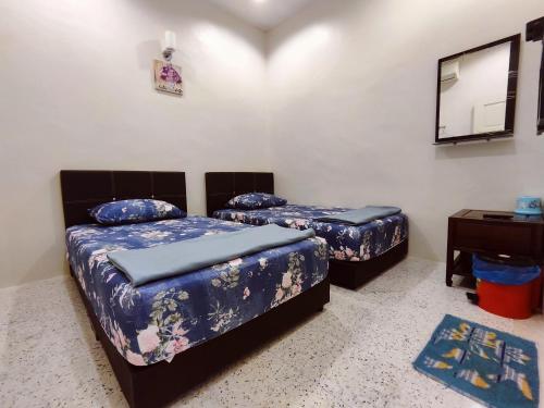 a bedroom with two beds and a mirror and a table at TREX_Batu Pahat Homestay in Batu Pahat
