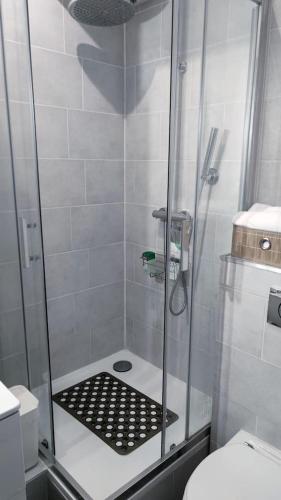 une douche avec une porte vitrée dans une salle de bain dans l'établissement Appartement T2 Chic and White avec WIFI, à Livry-Gargan