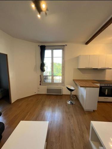 une pièce vide avec une cuisine et une fenêtre dans l'établissement Appartement T2 Chic and White avec WIFI, à Livry-Gargan
