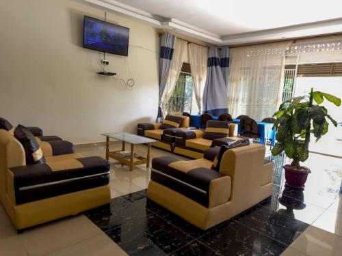 uma sala de estar com sofás e uma televisão de ecrã plano em Contra Hotel em Jinja