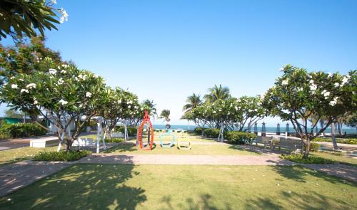 a park with a playground and trees and the ocean at Villa Nilaya - Beachfront Villa - Hua Hin in Ban Bo Fai