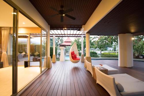 a house with a porch with a couch and chairs at Villa Nilaya - Beachfront Villa - Hua Hin in Ban Bo Fai
