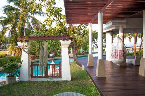 a house with a wooden deck and a swimming pool at Villa Nilaya - Beachfront Villa - Hua Hin in Ban Bo Fai