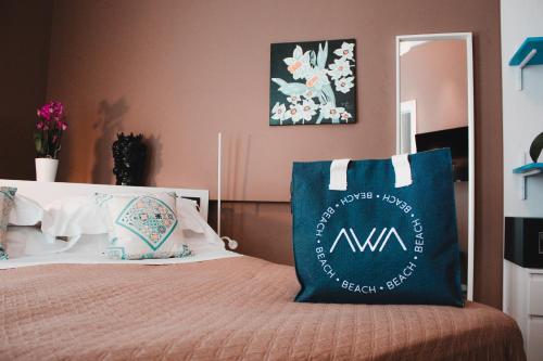 a bed with a blue and white pillow on it at AWA Mondello in Mondello
