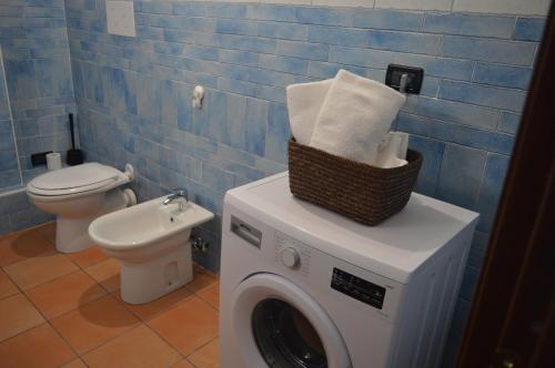 a bathroom with a washing machine and a toilet at Country House Il Papavero Rosso in Francavilla al Mare