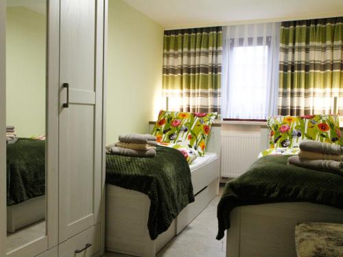 a small room with two beds and a window at Ferienwohnung Familie Mergner in Bad Langensalza