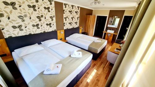 ein Hotelzimmer mit 2 Betten und Handtüchern darauf in der Unterkunft Gasthof Kreischberg in Sankt Georgen ob Murau