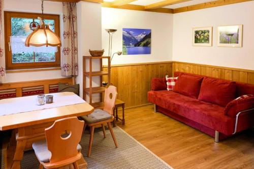 - un salon avec un canapé rouge et une table dans l'établissement Apartment in K nigsleiten with a shared sauna, à Königsleiten