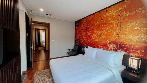- une chambre avec un lit blanc et une peinture murale dans l'établissement Shoptel Wyndham Lynn Times Thanh Thủy, à La Phu