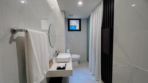 La salle de bains est pourvue d'un lavabo, de toilettes et d'un miroir. dans l'établissement Shoptel Wyndham Lynn Times Thanh Thủy, à La Phu