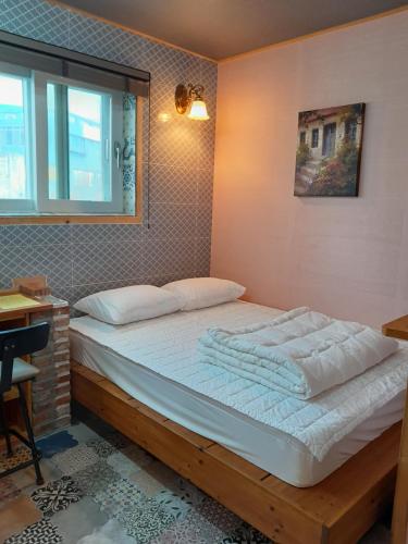 duże łóżko w pokoju z oknem w obiekcie Deluna House w mieście Mokpo