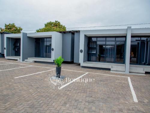 a building with a plant in a parking lot at Elephant Boutique Lodge in Tswinga