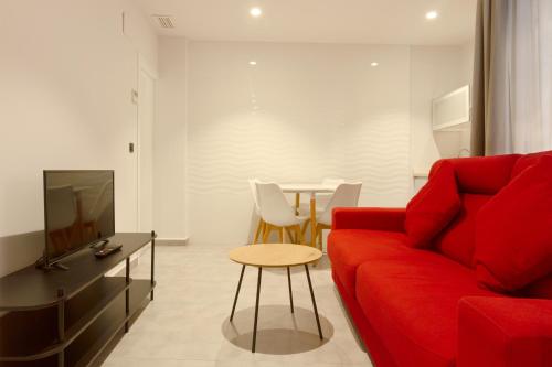 a living room with a red couch and a table at Hotel La Milagrosa in Alicante