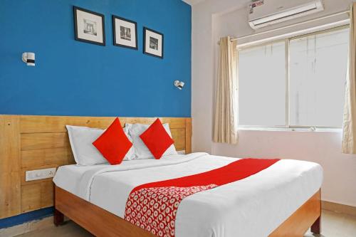 una camera da letto con un letto con pareti blu e cuscini rossi di OYO Flagship 84826 Hotel Silver Key a Méribel Village