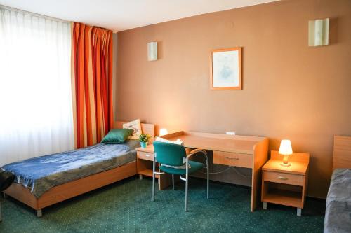 a hotel room with a desk and a bed and a desk and a desk at Hotel Wilanów in Warsaw