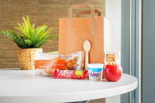 a paper bag sitting on a table with food and an apple at Rooms Inn in Newcastle upon Tyne