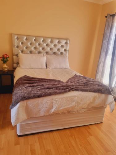 a bedroom with a large bed with a large headboard at Home Life Guesthouse in Midrand