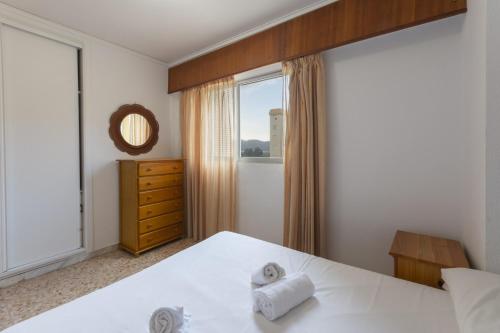 a bedroom with a white bed and a window at Bahamas in Caserío La Estación