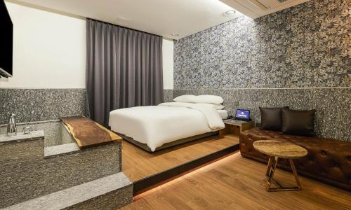 a bedroom with a bed and a desk and a couch at Incheon Guwol Hotel Bay 204 in Incheon
