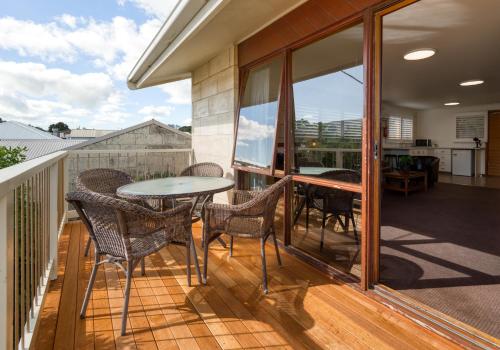 een patio met een tafel en stoelen op een balkon bij Loch Ard Motor Inn in Port Campbell