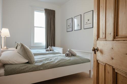 a white bedroom with a bed with a window at Ventnor Views in Ventnor