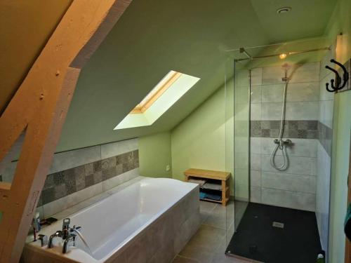 a bathroom with a large tub and a shower at Maison Les Roses in Marmagne