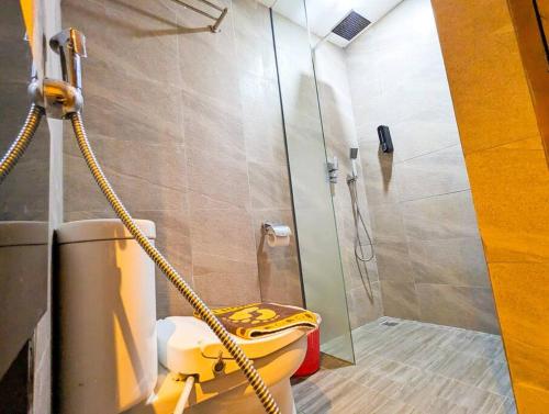 a bathroom with a yellow toilet and a shower at Lovina 9-17 at Harbour Bay Residence(Near Ferry) in Batu Ampar