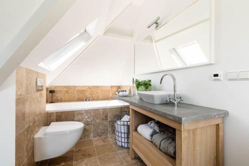 uma casa de banho com um lavatório, um WC e uma banheira em Beautiful house close to Amsterdam Beach and Haarlem em Aerdenhout