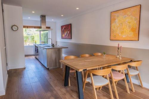 uma cozinha e sala de jantar com uma mesa de madeira e cadeiras em Beautiful house close to Amsterdam Beach and Haarlem em Aerdenhout