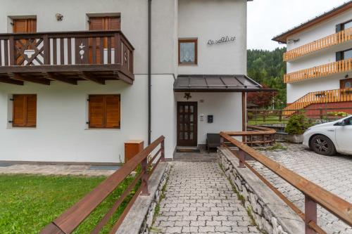 a house with a balcony and a car parked outside at Casa Alice in Falcade