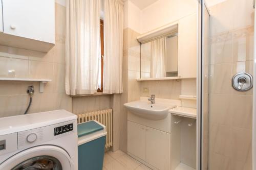 a small bathroom with a washing machine and a sink at Casa Alice in Falcade