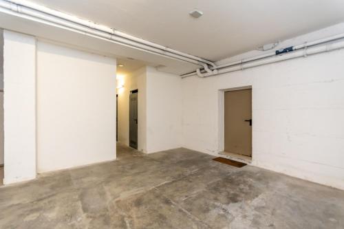 an empty room with white walls and concrete floors at Casa Alice in Falcade