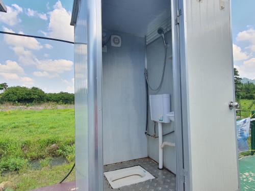 uma casa de banho com chuveiro e WC num campo em OYO Home 90851 Rb Homestay & Farms 2 em Kuching