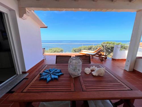 uma mesa numa varanda com vista para o oceano em TITINO stupendo appartamento in villa fronte Mare - Golfo dell'Asinara - Internet Free em Codaruina