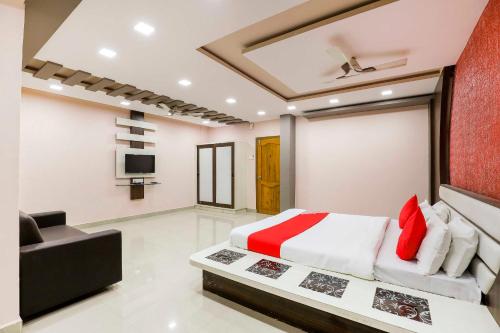 1 dormitorio con cama, sofá y TV en Collection O Shree Dhoramnath en Nakhtarāna